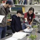 Biodiversity Museum Day photo showing students gathered around a microscope.